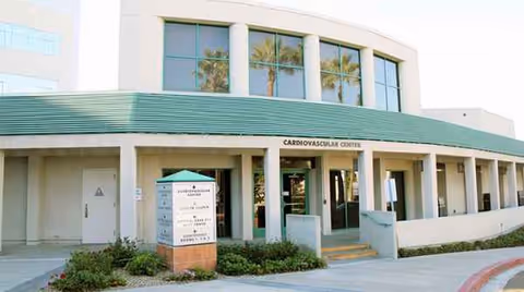 Exterior view of a medical facility with green awning, columns, and Cardiovascular Center entrance.