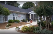 Front exterior view of Bayberry Retirement Inn with walkway and potted plants.