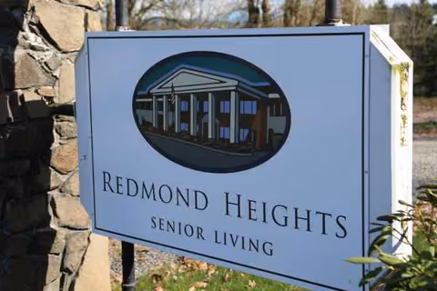 Outdoor sign for Redmond Heights Senior Living with building illustration