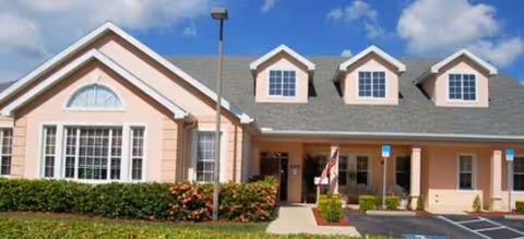 Front view of Brookdale Rotonda facility with peach exterior, dormer windows, and entrance.