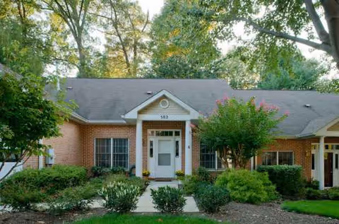 Wilson Health Care Center entrance: brick building, white door, portico, and surrounding greenery.