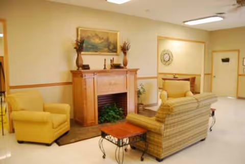 Interior common area with seating, a fireplace, and artwork.