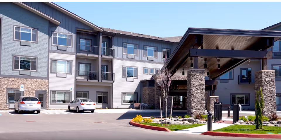 Exterior view of Boone Ridge Retirement Community with entrance canopy and parked cars.