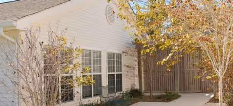 Exterior view of Brookdale Morehead City building with trees and a walkway.