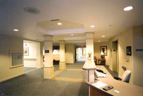 Interior corridor of Arbor Ridge with a reception desk, seating, and doors.