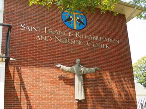 Brick building exterior with Saint Francis Rehabilitation and Nursing Center sign and statue.