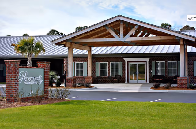 Front view of Reflections Assisted Living facility with brick exterior and covered entry.