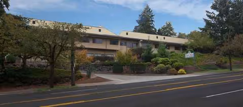 Exterior view of Park Rose Care Center building with landscaped front and street in foreground.