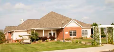 Single-story brick senior living facility with manicured lawn and a white front entrance.
