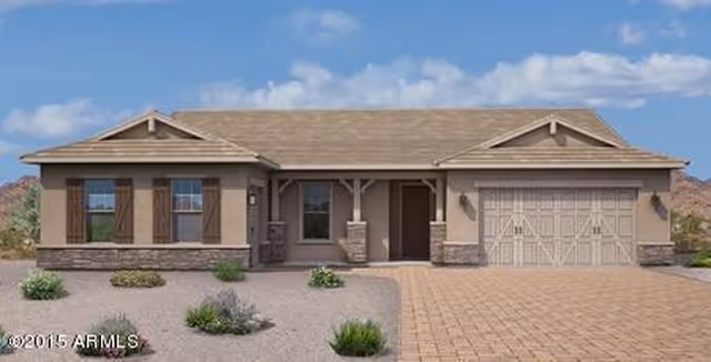 Single-story house with a beige exterior, stone accents, a two-car garage, and a tiled roof. The front yard features desert landscaping with small bushes and gravel. The sky is partly cloudy.