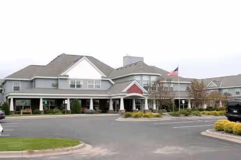 Exterior view of Guardian Angels by the Lake Senior Living in Elk River, with parking lot.
