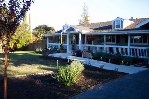A single-story senior living facility with a covered front porch and landscaped yard.