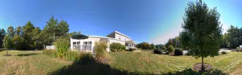 Panoramic view of Serenity Hill Nursing & Rehabilitation Center exterior with lawn and trees.