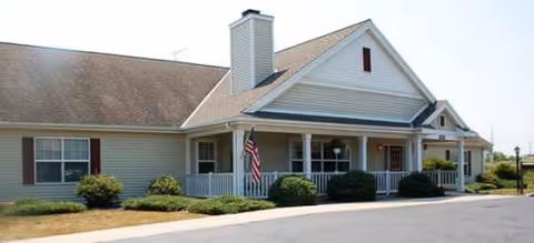 Single-story Brookdale Faribault facility with front porch, flag, and neatly trimmed shrubs.