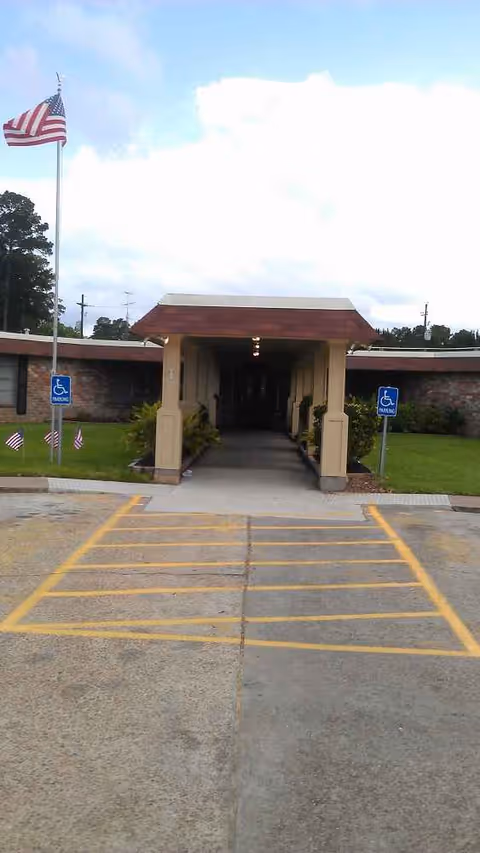 Front entrance of Woodland Manor Nursing & Rehabilitation with a covered walkway and handicapped parking.