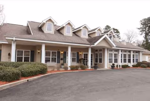 Exterior view of Trustwell Living at Russ Place with porch columns and parking.
