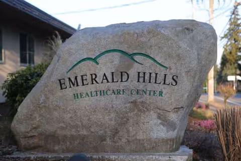 A large rock sign displays Emerald Hills Healthcare Center at the facility entrance.