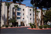 Exterior view of Christian Care Manors I & III building with palm trees and parking.