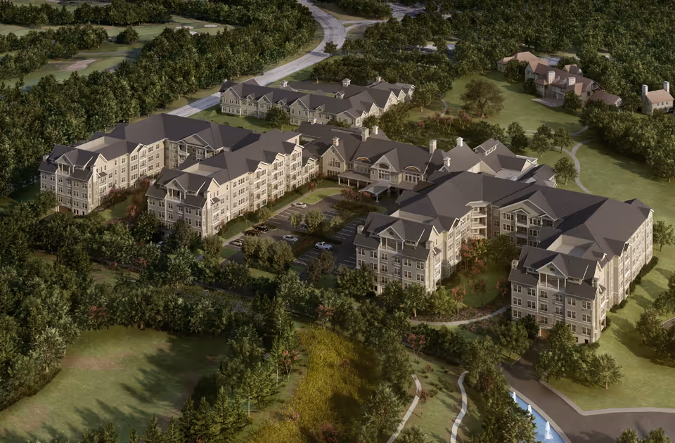 Aerial view of Broadview Senior Living at Purchase College showing multiple large residential buildings surrounded by trees, greenery, and pathways, with a parking lot and a road nearby.
