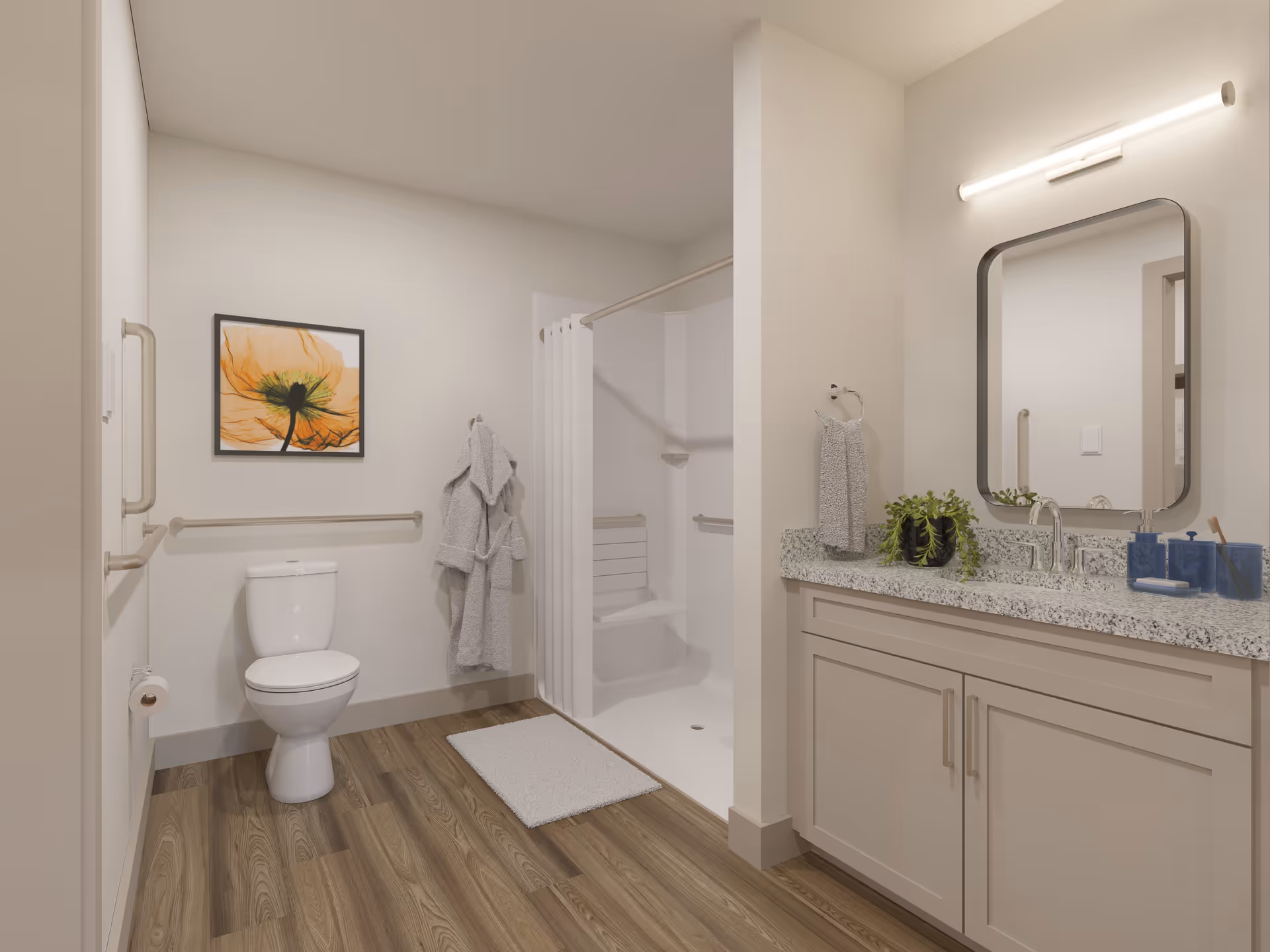 A clean, modern bathroom with a white toilet, a walk-in shower with a built-in seat and grab bars, a vanity with a granite countertop, a rectangular mirror, and a light fixture above it. The bathroom has wood-look flooring, a white bath mat, a towel ring with a gray towel, a hanging gray bathrobe, and a framed orange flower artwork on the wall.
