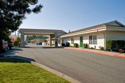 Exterior view of a single-story facility with a covered entrance and driveway at Life Care Center.