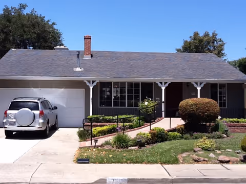 Front view of a single-story senior living home with a garage and landscaped yard.