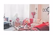 Cozy living room with sofas, a coffee table, lamp, TV, and vertical blinds.