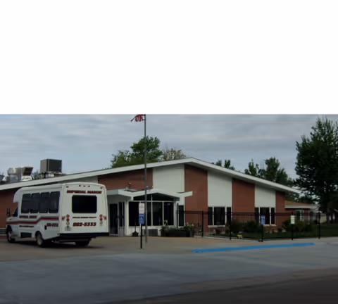 Front view of Elms Health Care Center with a bus parked outside.