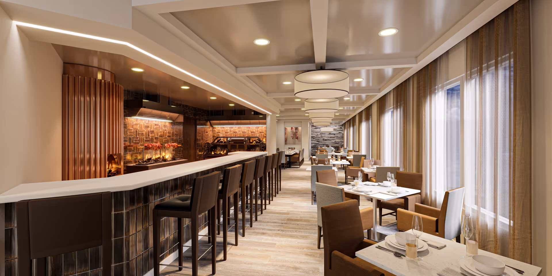 A modern dining room with a long bar counter on the left side featuring high bar stools, and several dining tables with chairs set with plates, glasses, and cutlery on the right side near large windows with sheer curtains. The room has warm lighting, wooden flooring, and decorative ceiling lights.