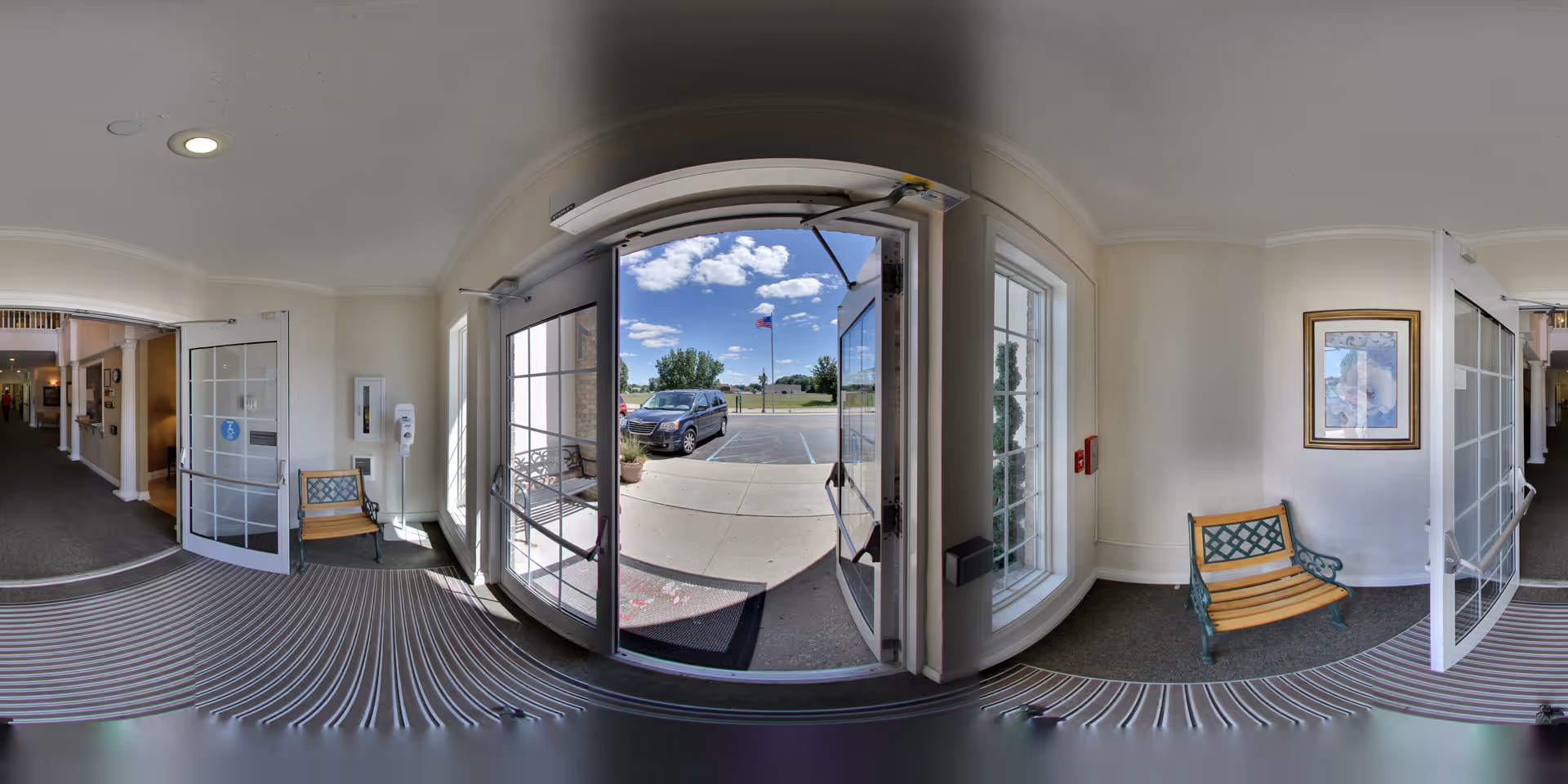 A view from inside a senior living facility showing the entrance with double doors leading outside.