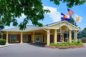 Front view of Hallmark Nursing Center entrance with flags and curved canopy.