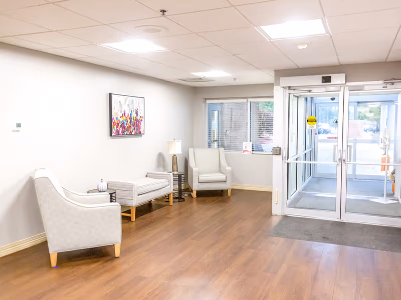 A welcoming lobby area with two armchairs, a small table, and a light fixture.
