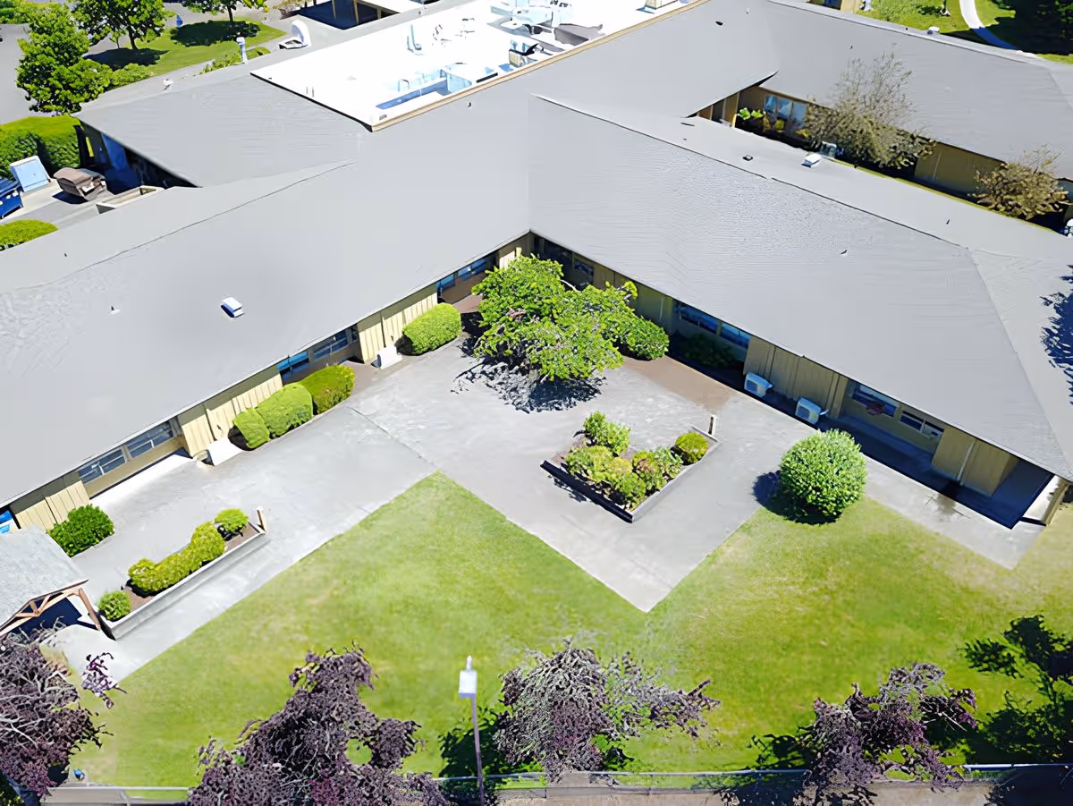 Aerial view of a senior living facility courtyard surrounded by single-story buildings, walkways, and landscaped greenery.