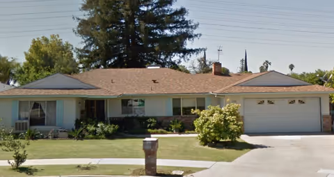 Single-story house with a two-car garage and a manicured front lawn.
