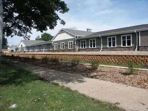 Exterior view of a single-story Westhaven Community building with gray siding and stone foundation.