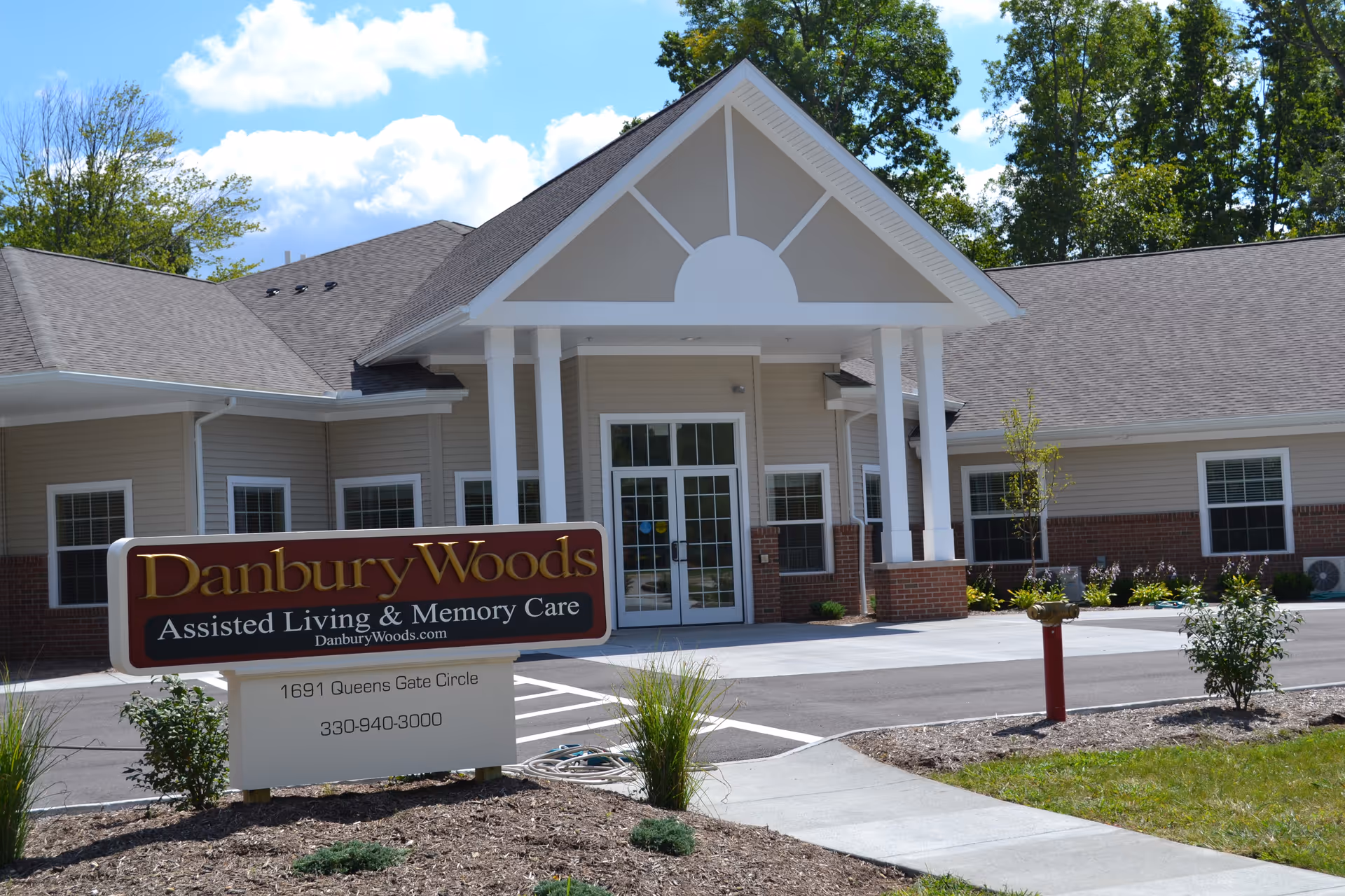 Exterior view of Danbury Woods assisted living facility entrance with sign.