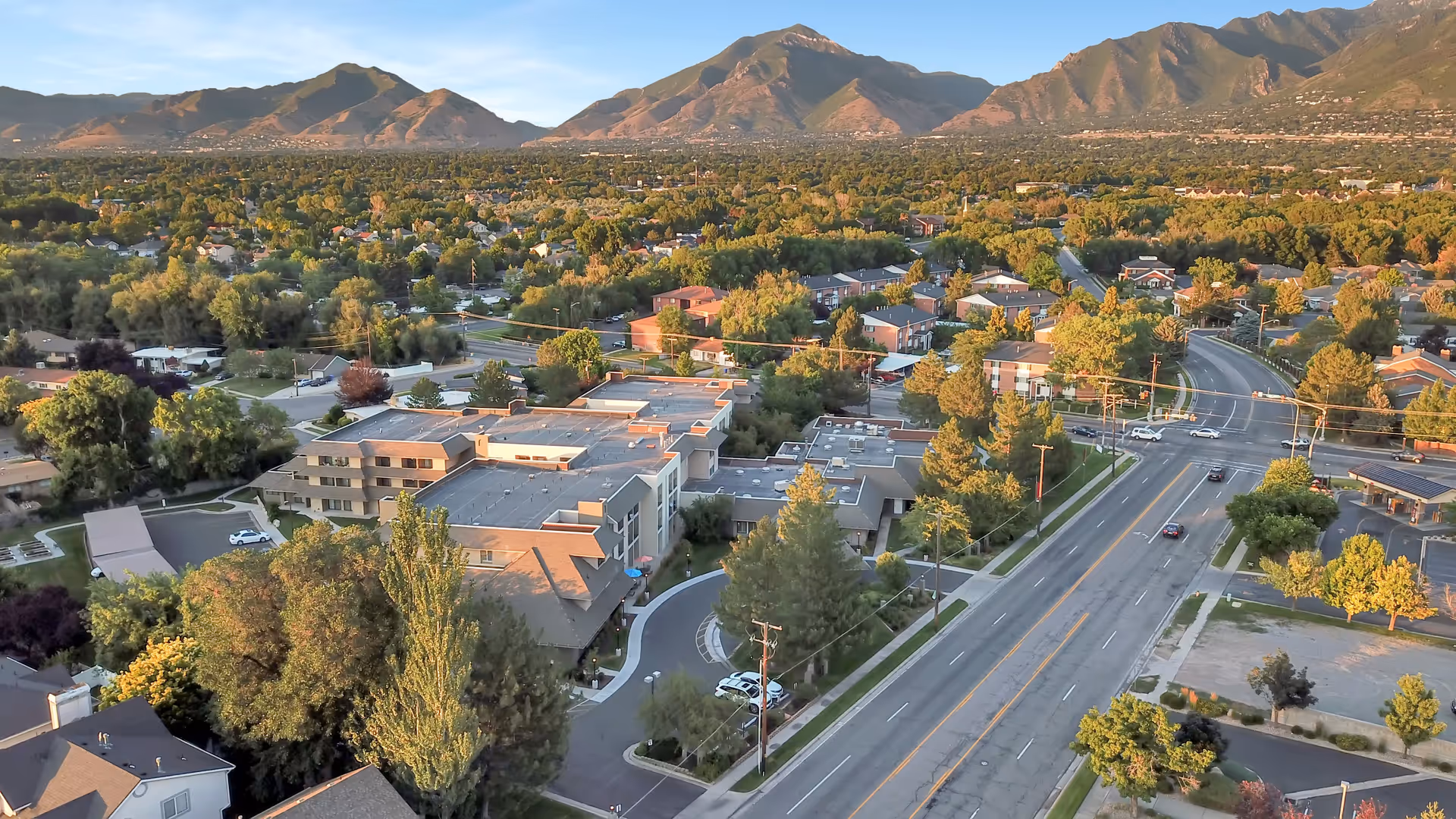 Aerial view of the Cottonwood Creek senior living campus and surrounding neighborhood with mountains in the background.