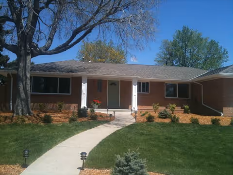 One-story brick assisted living facility front with walkway and landscaping.