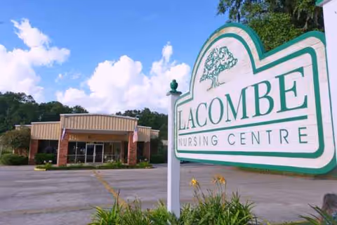 Exterior view of Lacombe Nursing Centre entrance with a large green and white sign