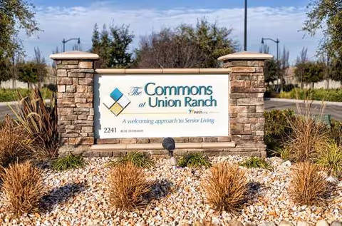 Stone entrance sign for The Commons at Union Ranch with surrounding drought-tolerant landscaping.