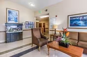 Lounge area of a senior care facility with sofa, chairs, and a coffee table.