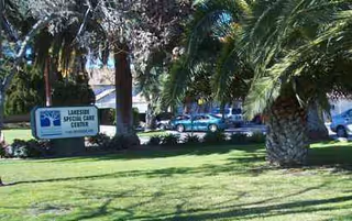 Exterior view of Lakeside Special Care Center with palm trees and a sign.