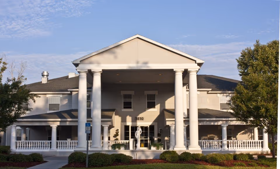 A large, white, columned senior living facility with a grand portico.