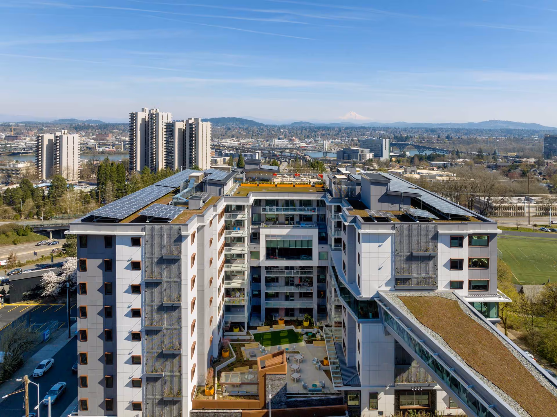 Aerial view of the Terwilliger Plaza Retirement Community surrounded by urban landscape and mountains.