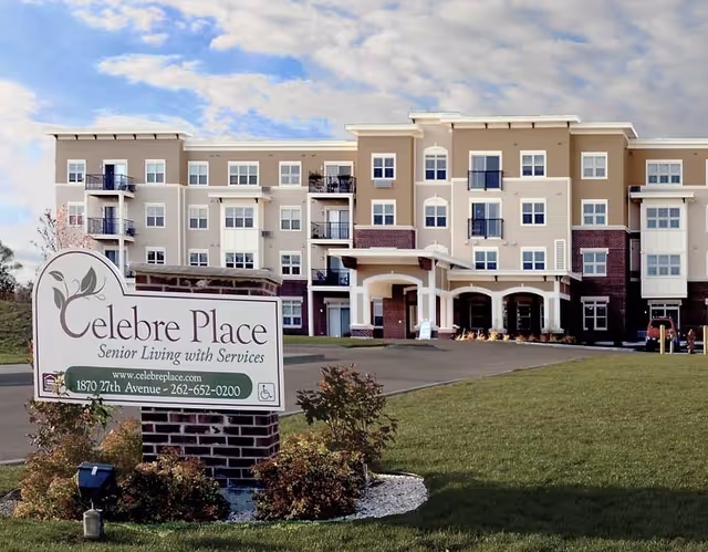 Front exterior of the Celebre Place senior living building with its entrance and a lawn sign in the foreground.