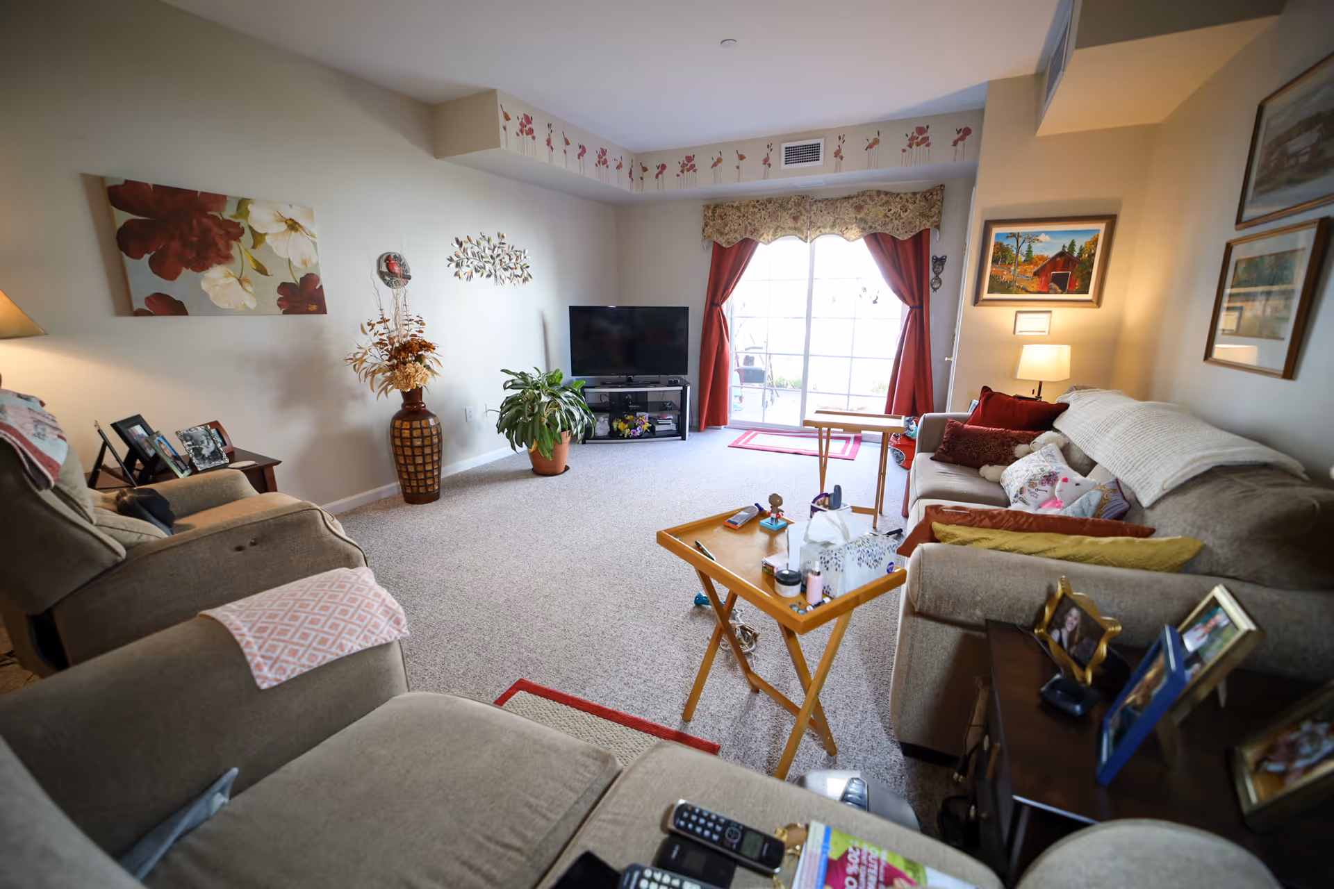 Cozy living room with couches, coffee table, TV, and sliding glass door