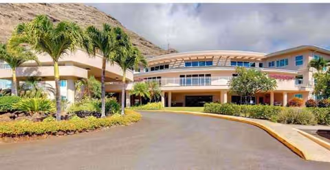 The Ivy at Hawaii Kai exterior building with palm trees and curved driveway entrance.