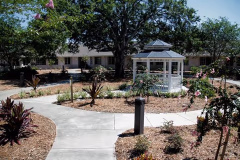 Exterior view of Magnolia Gardens ALF featuring a gazebo and landscaped courtyard