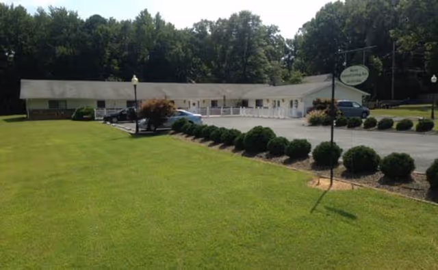 Front exterior of Bowie Assisted Living, with green lawn, shrubs, and parking lot.