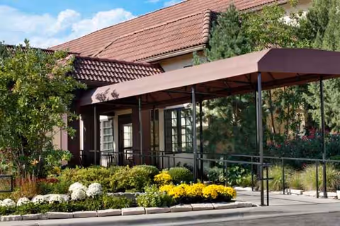 Exterior of Senior Star at Villa Ventura facility with landscaping and a covered entrance.